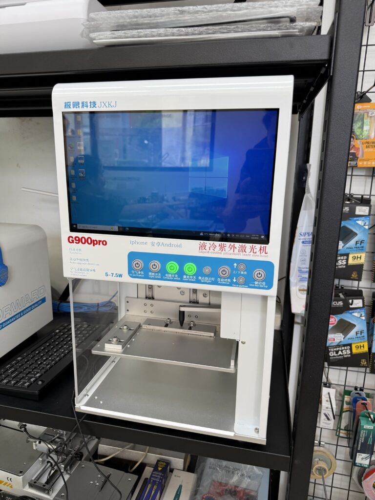 เครื่องเลเซอร์ที่มีหน้าจอควบคุมและแท่นวางอุปกรณ์ในร้านซ่อม